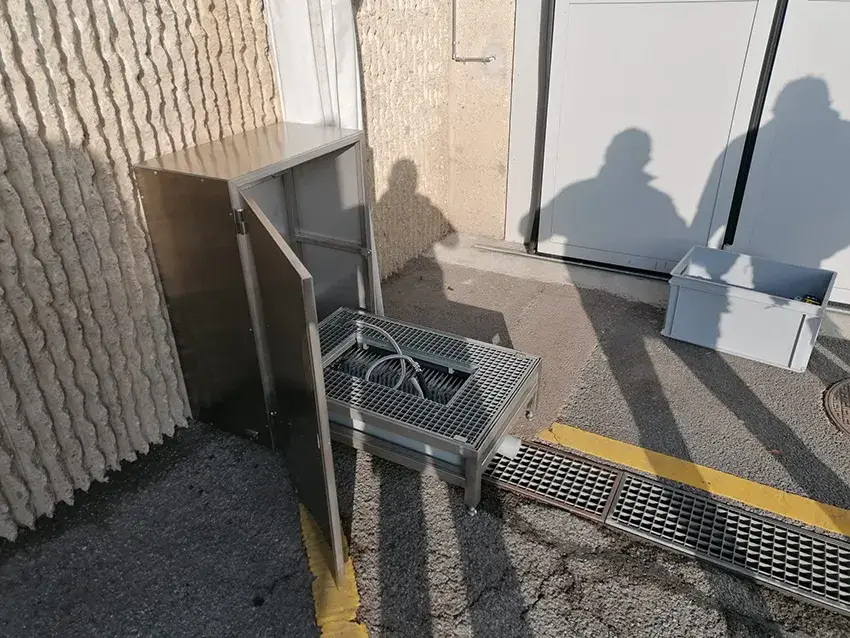 Caisson en inox ouvert, posé sur une grille de sol