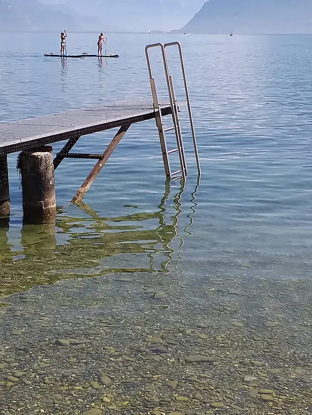 Échelle de bain en inox fixée à un ponton, au bord du lac