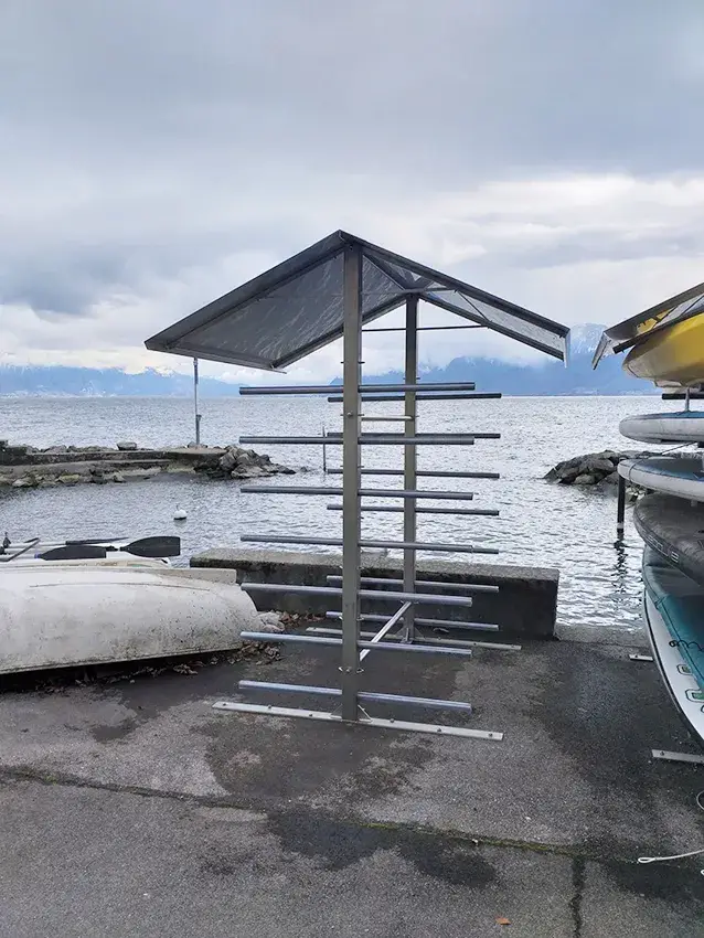 Râtelier métallique couvert pour paddles, au bord du lac