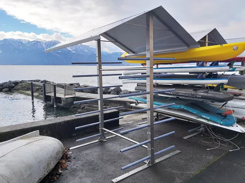 Râtelier couvert chargé de paddles et de kayaks au bord du lac