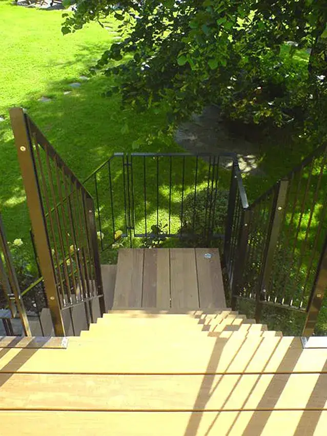 Garde-corps métallique noir à barreaux de part et d'autre d'un escalier extérieur