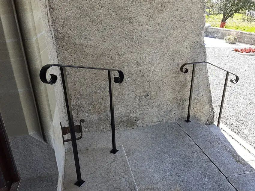 Mains courantes en fer forgé noir de part et d'autre d'une entrée