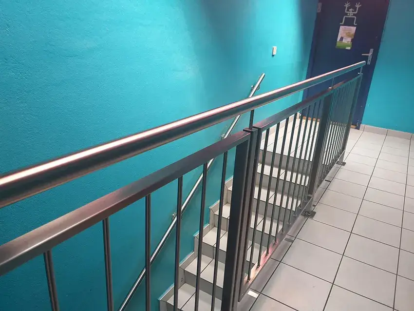 Balustrade en inox à barreaux verticaux dans une cage d'escalier