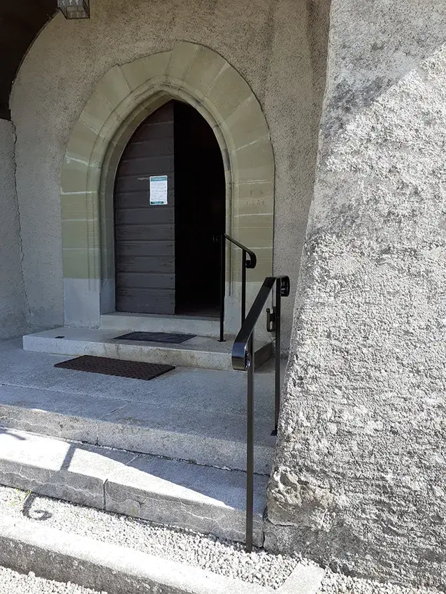 Main courante en fer forgé noir à l'entrée d'un bâtiment ancien