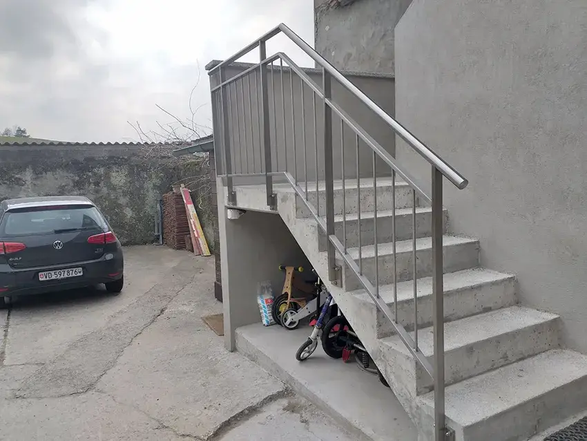 Garde-corps et main courante en inox sur un escalier extérieur en béton