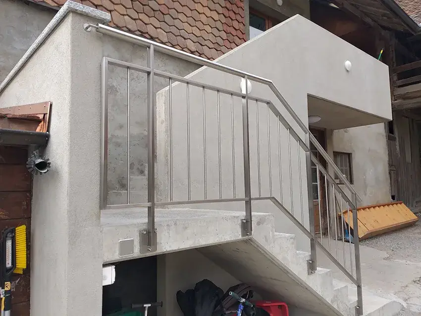 Garde-corps en inox à barreaux verticaux sur l'escalier extérieur d'un immeuble