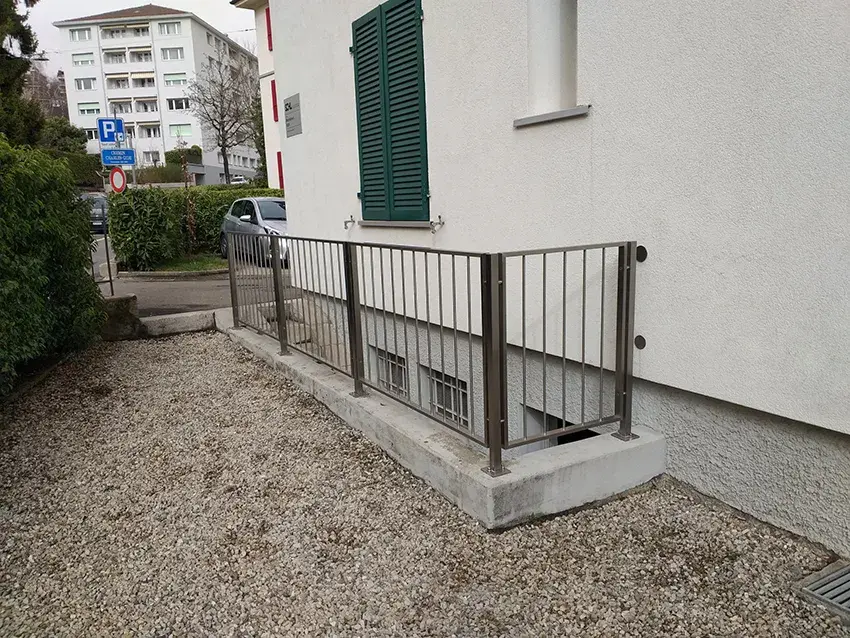 Barrière métallique à barreaux autour d'une descente de sous-sol