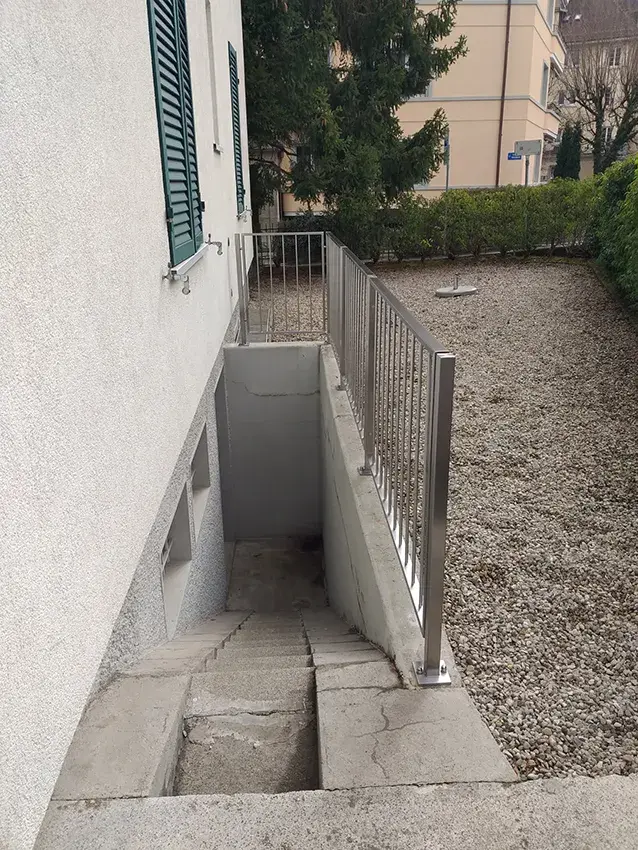 Barrière en inox à barreaux le long d'une descente d'escalier extérieure