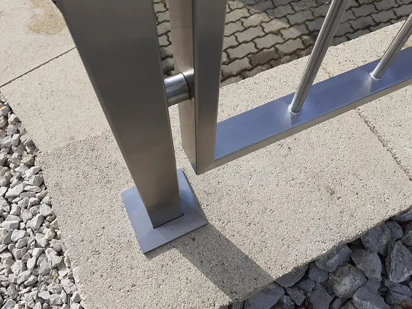 Détail d'un poteau en inox fixé sur platine au sol
