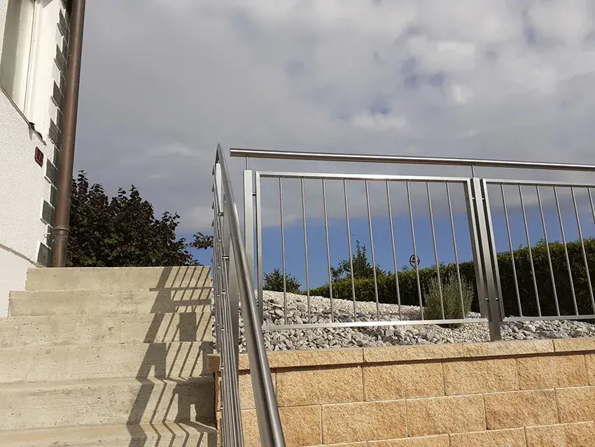 Garde-corps en inox à barreaux sur un muret, au bord d'un escalier