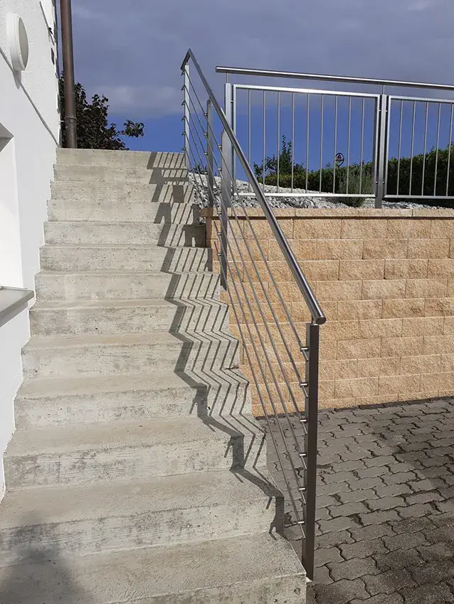 Garde-corps en inox le long d'un escalier extérieur, vue depuis le bas