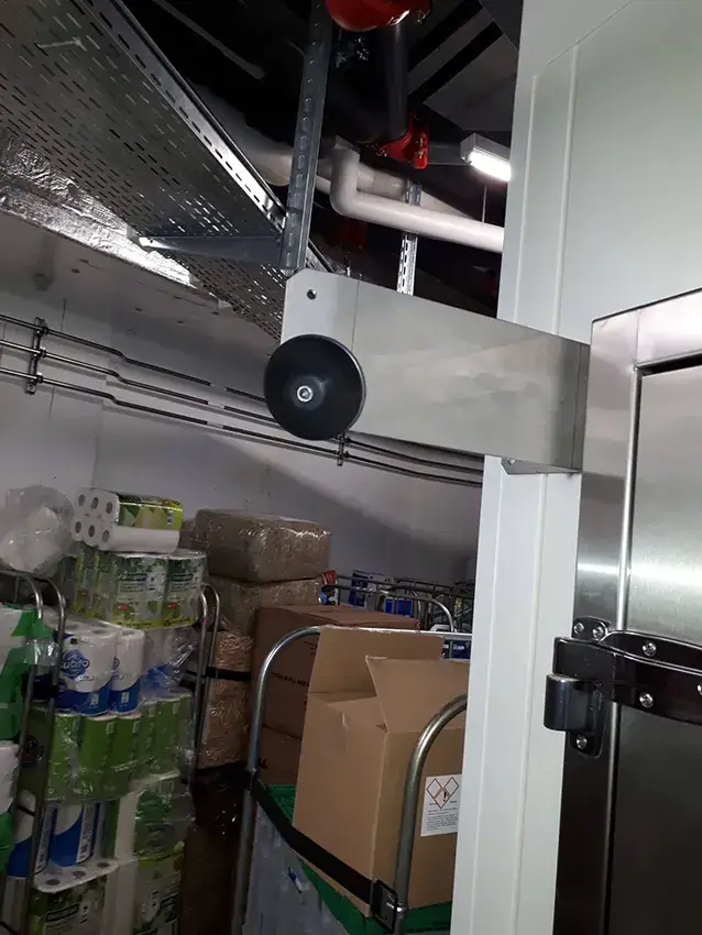 Butée de porte en inox fixée au mur d'une réserve