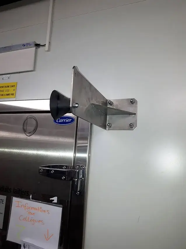 Butée de porte en inox à côté d'une porte de chambre froide