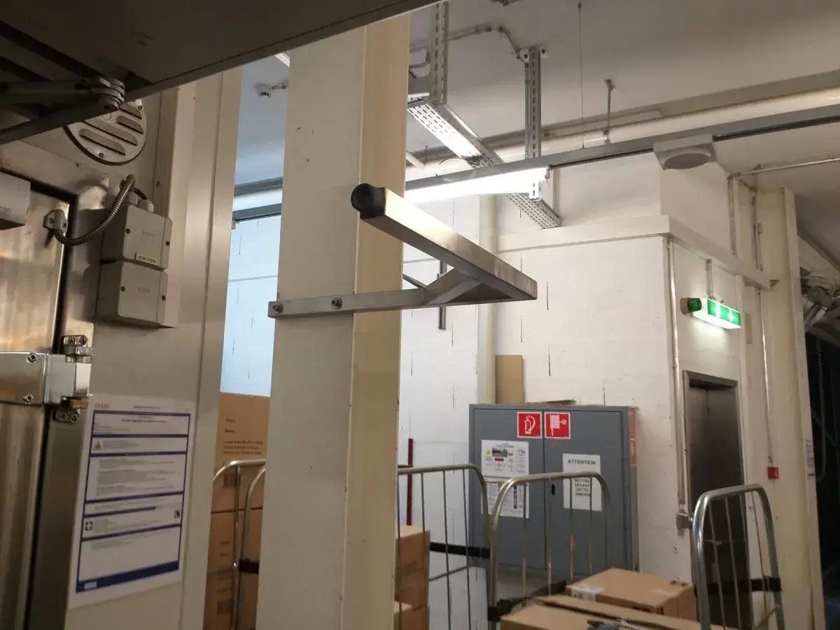 Potence en inox fixée à un poteau dans un local de stockage