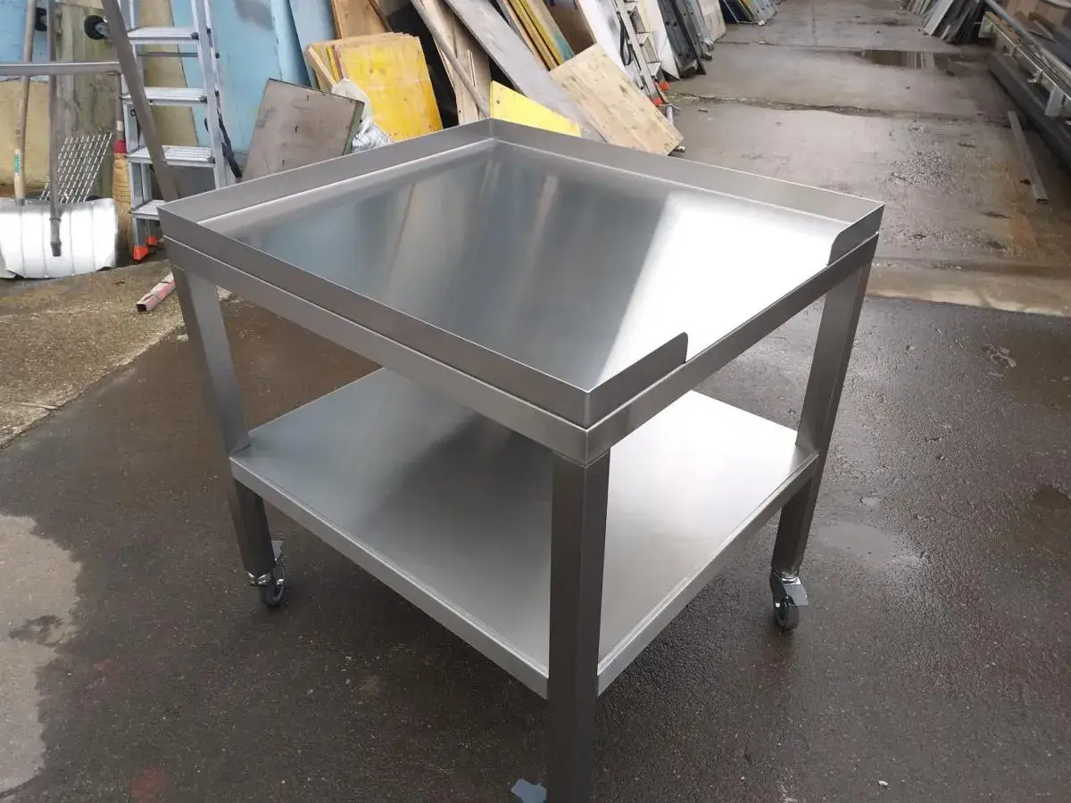 Table de travail en inox à deux plateaux, sur roulettes