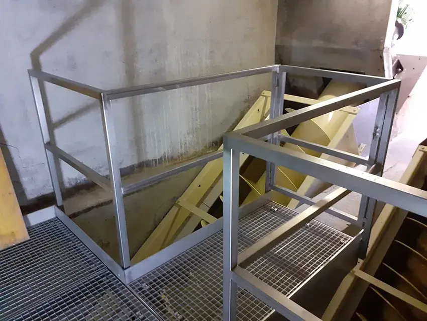 Garde-corps métallique autour d'une passerelle en caillebotis