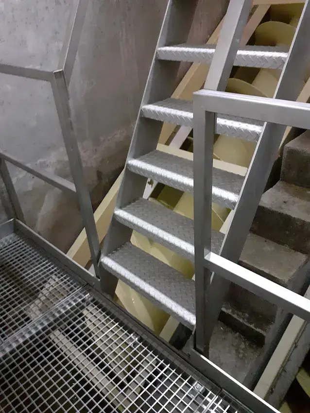 Escalier métallique à marches en caillebotis avec garde-corps