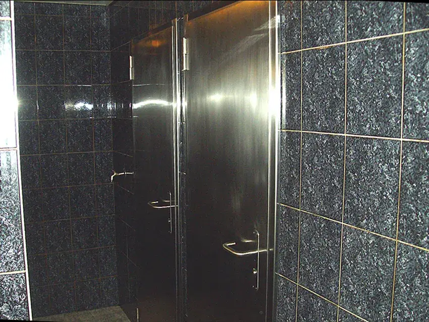 Porte habillée d'inox dans un hall carrelé