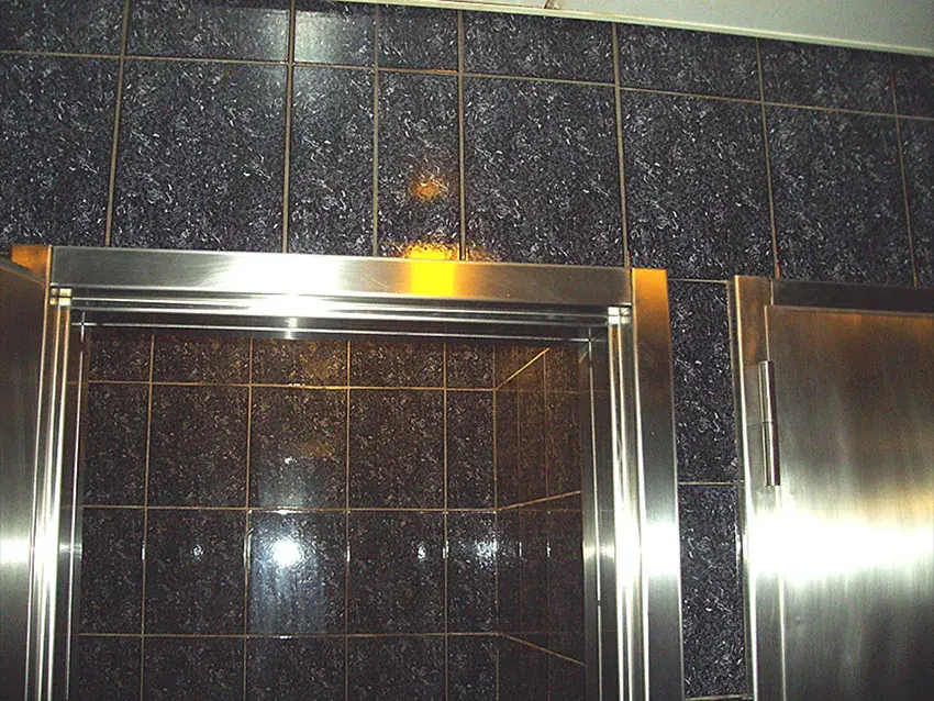 Encadrement de porte en inox poli dans un hall carrelé
