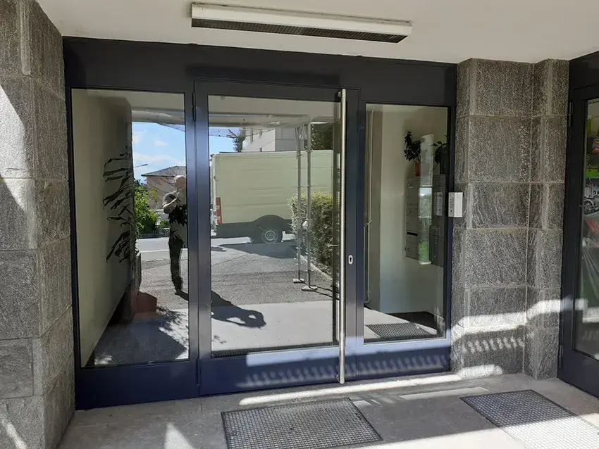 Porte d'entrée vitrée à cadre métallique, vue de l'intérieur