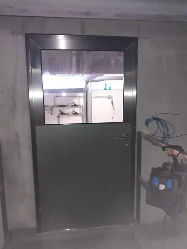 Porte métallique avec partie vitrée dans un local technique